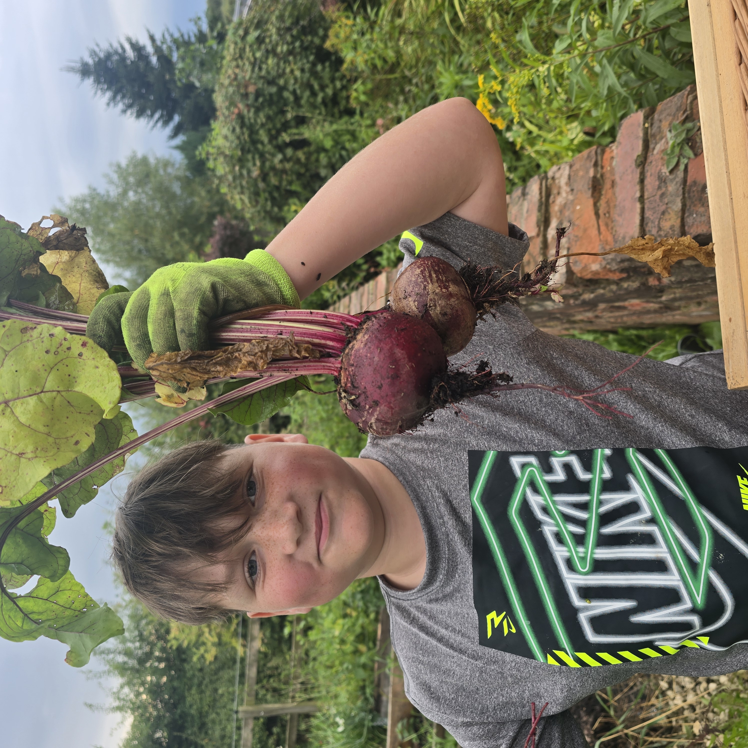 A young grower proudly holding freshly harvested beetroot at Moss Lane Farm